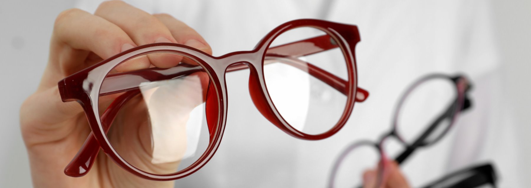 A person holding a pair of red-rimmed glasses at Mechanicsburg Pennsylvania